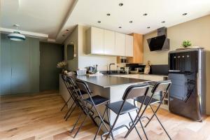 a kitchen with a large island with stools at Appartement spacieux avec balcon 6pers in Lyon