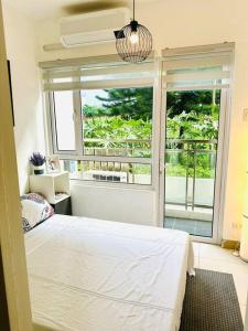 a bedroom with a bed and a large window at Cool and Savvy 1BR @Cool Suites Tagaytay in Tagaytay