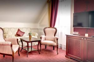 a living room with a couch and a table and chairs at Boutique Hotel Hviezdoslav in Kežmarok