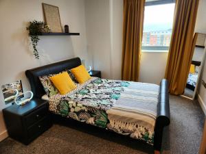 a bedroom with a bed and a couch and a window at Stylish 2 bed & 2 bath City Centre Apartment with FREE PARKING in Sheffield