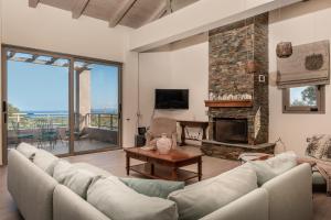 a living room with a couch and a fireplace at Astarte Villas - Stilvi 4 Bedroom Private Villa With Pool in Akrotiri