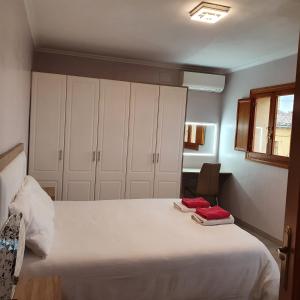 a bedroom with a large white bed with white cabinets at Belle villa à Oliva proche de la mer et de la montagne in Oliva