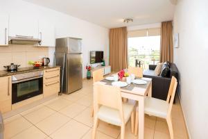 een keuken en eetkamer met een tafel en stoelen bij Apartment Austin - Coralli Beachfront Resort in Protaras
