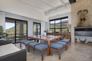 a dining room with a table and chairs and a fireplace at Hangklip Villa by Host Agents in Pringle Bay
