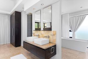 a bathroom with two sinks and a large mirror at Hangklip Villa by Host Agents in Pringle Bay
