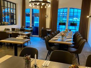een eetkamer met tafels, stoelen en ramen bij Bischoffs Hotel in Bad Urach