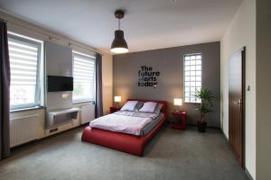 1 dormitorio con cama roja y TV en Vigo Hotel en Lodz