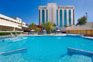 a large swimming pool in front of a hotel at Crowne Plaza Amman, an IHG Hotel in Amman