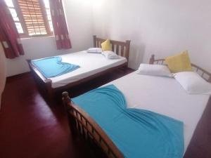 two twin beds in a room at Sunshine Guest House in Polonnaruwa