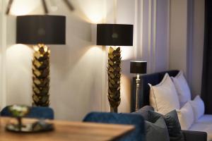 ein Wohnzimmer mit einer Couch und einem Tisch mit zwei Lampen in der Unterkunft R B Apartment Hamburg Business am Flughafen für 1-5 Personen - ideal für Geschäftsreisende und Familien - Küche - Waschtrockner - Smart TV - kostenloser Parkplatz in Hamburg