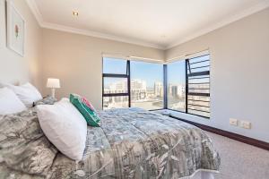 a bedroom with a large bed and a large window at Luxury 3 bedroom Duplex Penthouse with communal swimming pool in Bloubergstrand +48 photos
