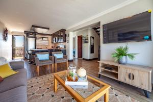 a living room with a large flat screen tv at Luxury 3 bedroom Duplex Penthouse with communal swimming pool in Bloubergstrand
