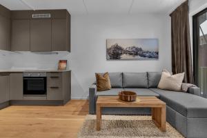 uma sala de estar com um sofá cinzento e uma mesa em Vervet - 1 bedroom with sofabed em Tromsø