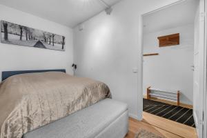 a bedroom with a bed and a bench in it at Vervet - 1 bedroom with sofabed in Tromsø