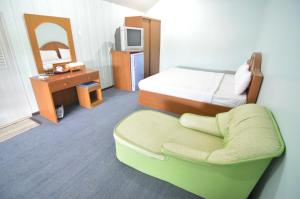una camera d'albergo con letto e sedia di Techno Riverview Resort a Kamphaeng Phet