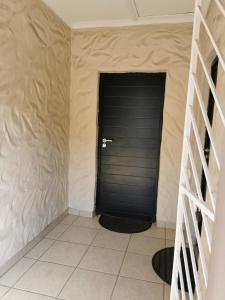 a black door in a room with a tiled floor at Arabella in Durban