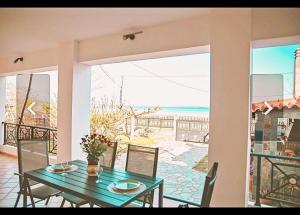 una sala da pranzo con tavolo e vista sull'oceano di Κatakolo Luxury Seaside House & Garden a Katakolo