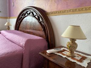 um quarto com uma cama e uma mesa com um candeeiro em House Giulia al Borgo Marinaro em Avola