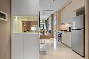 a kitchen with white cabinets and a bar in it at Vivida by Kozystay - 1BR - Resort Pool - Cilandak in Jakarta