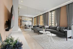 ein Wohnzimmer mit einem Sofa und einem Tisch in der Unterkunft Vivida by Kozystay - 1BR - Resort Pool - Cilandak in Jakarta