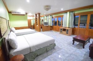 a bedroom with two beds and a television in it at Techno Riverview Resort in Kamphaeng Phet