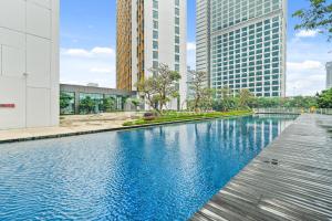ein Schwimmbad in einer Stadt mit hohen Gebäuden in der Unterkunft Vivida by Kozystay - 1BR - Resort Pool - Cilandak in Jakarta
