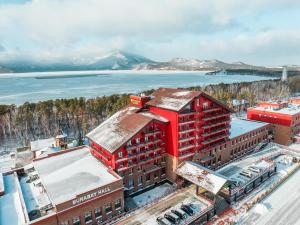 an aerial view of a red building in front of the water at Wyndham Garden Burabay in Borovoye