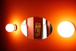 a mirror on a wall with lights on it at Hotel Memoire Kutaisi in Kutaisi