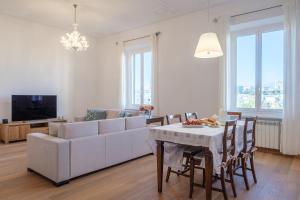 un soggiorno con divano bianco e tavolo di La Superba Loft a Genova
