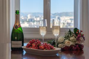 un tavolo con una bottiglia di champagne e un cesto di frutta di La Superba Loft a Genova