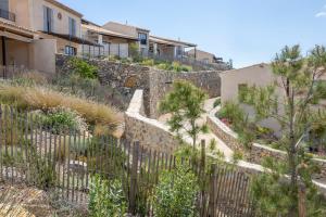 un muro de retención con una valla y árboles en Château Capitoul en Narbona