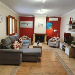 a living room with two couches and a fireplace at Belle villa à Oliva proche de la mer et de la montagne in Oliva