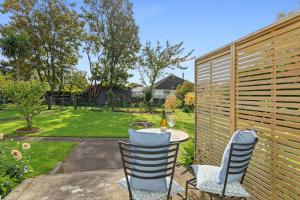 a patio with a table and chairs and a fence at Peaceful Country Retreat in Moutoa