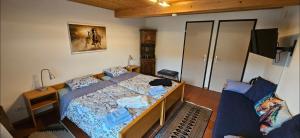 ein kleines Schlafzimmer mit einem Bett und einem Sofa in der Unterkunft Miramont Horse Trekking Hostel in Saicourt