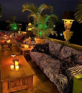 a living room with couches and a table with candles at RoofTop Boutique Hotel Adults Only in Serekunda