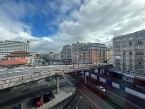 a bridge over a road in a city with buildings at De Cine in Oviedo