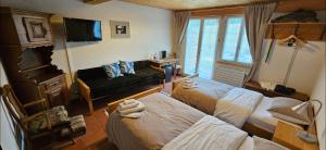 a hotel room with two beds and a television at Miramont Horse Trekking Hostel in Saicourt