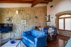 sala de estar con sofá azul y pared de piedra en Lago di Iseo - Lake View House (Casa sul Lago) en Tavernola Bergamasca