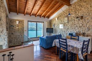 sala de estar con mesa y sofá azul en Lago di Iseo - Lake View House (Casa sul Lago) en Tavernola Bergamasca