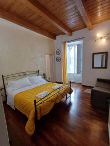 een slaapkamer met een geel bed en een bank bij Aquila Antica in LʼAquila