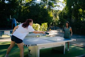 two women playing a game of table tennis at Camping Bela Basque - Maeva in Anglet