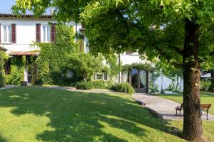 a house with a tree in the yard at PODERI LA ROCCHETTA Countryside Estate on the Hills of Lake Garda in San Felice del Benaco