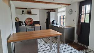 - une cuisine avec une table en bois dans une chambre dans l'établissement ferme de caractère avec piscine et cheminée, à Sainghin-en-Mélantois