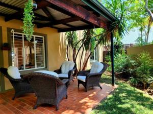 eine Terrasse mit Korbstühlen und einem Tisch in der Unterkunft Selah, self-catering in Pretoria