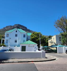 a white building with a fence in front of it at 31 Riverview in Cape Town