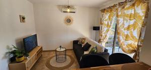 een woonkamer met een bank en een tv bij Villa 78 Alba Rossa Piscine chauffée et Plage de Cupabia in Serra-di-Ferro