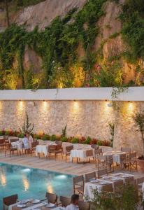 a restaurant with tables and chairs next to a swimming pool at Zoe Hora in Dhërmi