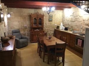 a kitchen with a table and chairs in a room at Charming 17th Cent House of Character in the famous 3 Cities, right next to Valletta in Cospicua
