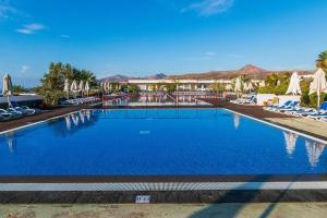 - une piscine avec des chaises et des parasols dans un complexe dans l'établissement Hotel Costa Calero Thalasso & Spa, à Puerto Calero