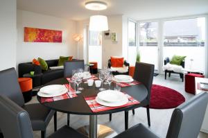 a dining room and living room with a table and chairs at MeerVerliebt C in Hörnum